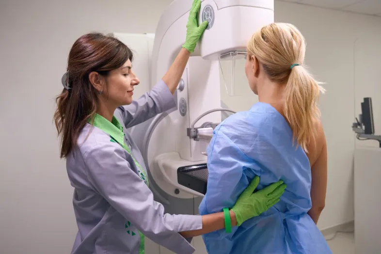 Woman receiving mammogram from a female doctor.
