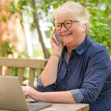 Smiling elderly woman using computer.